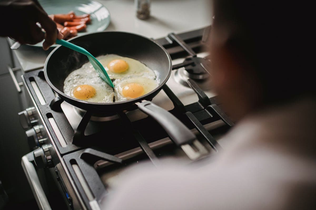 White ceramic-coated frying pan with a long handle, top down