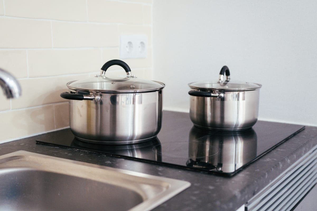 Two stainless steel pans side by side showing bonded base edges