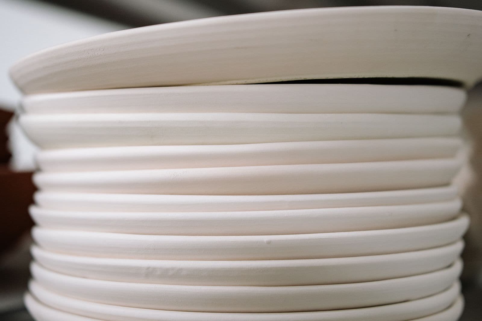 Clear glass plates and bowls stacked on a plain surface