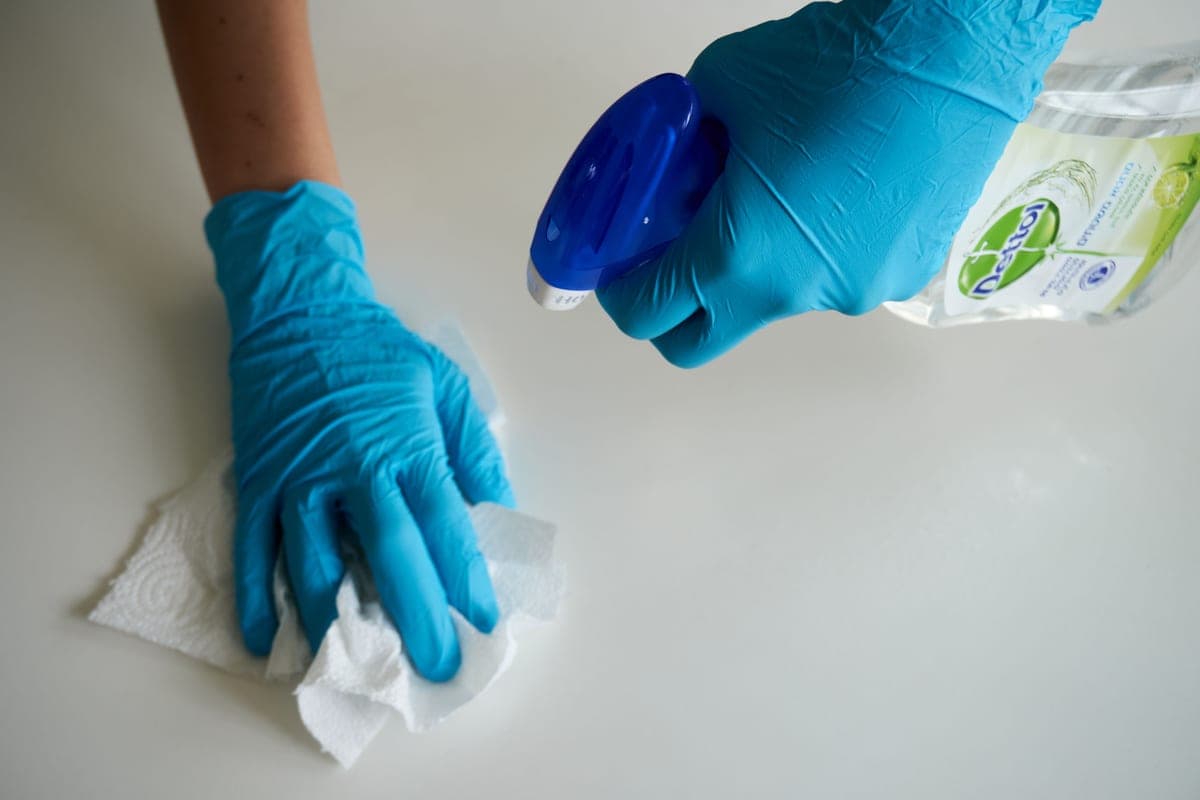 Disinfectant spray bottle beside a cleaning cloth