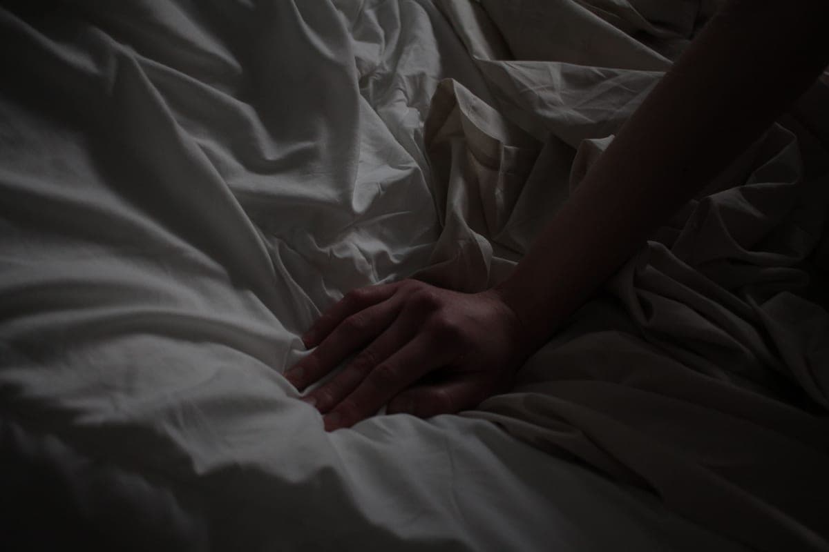 Folded cotton sheets beside textured linen fabric