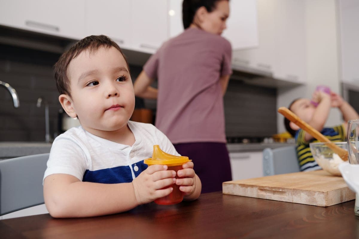 Glass toddler cup with a silicone sleeve on a table